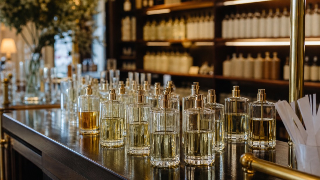 Rows of unlabeled perfume tester bottles on a polished counter in an elegant Paris perfumery interior