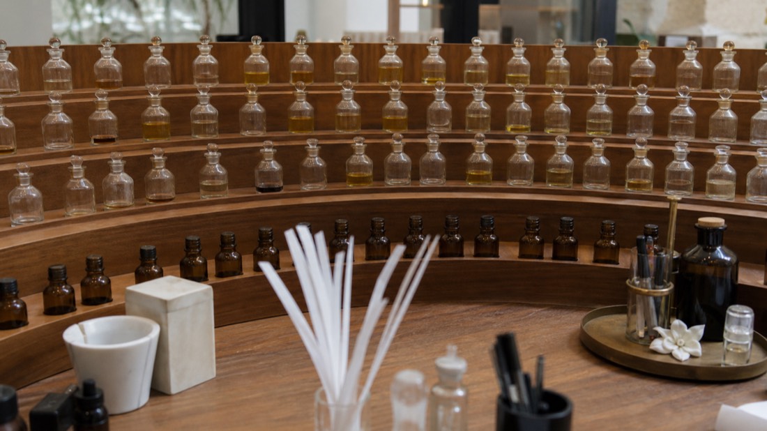 Perfumer's organ of tiered unlabeled essence bottles ready for an English-language workshop session in Paris