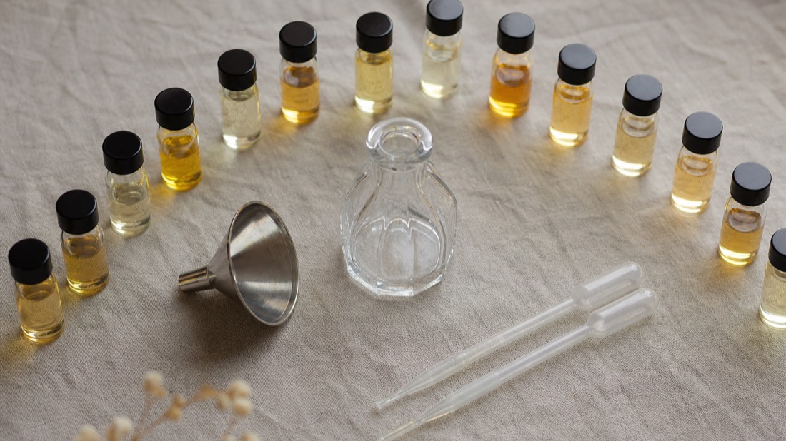 Open workshop kit with pipettes, blank flacon and essence bottles arranged on linen, what a Paris perfume workshop fee includes